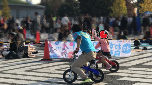 子ども自転車でハイタッチする